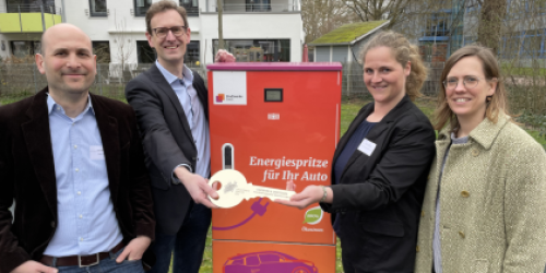Vier Vertreter von Stadt Soest und Zukunftsnetz posieren mit einem großen Schlüssel